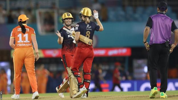 Las jugadoras de RCB Heather Knight y Ellyse Perry celebran su victoria contra Gujarat Giants