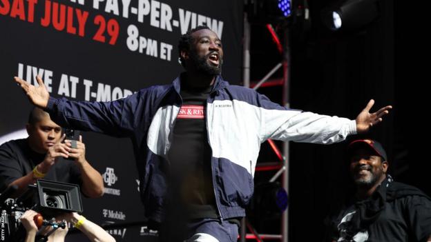 Terence Crawford opens his arms as he makes his entrance at a weigh-in