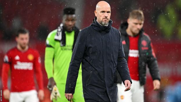 Manchester United players and manager Erik ten Hag walk off the pitch following Sunday's deby defeat