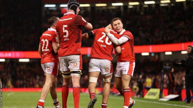 Alex Mann of Wales celebrates scoring a try with team mates