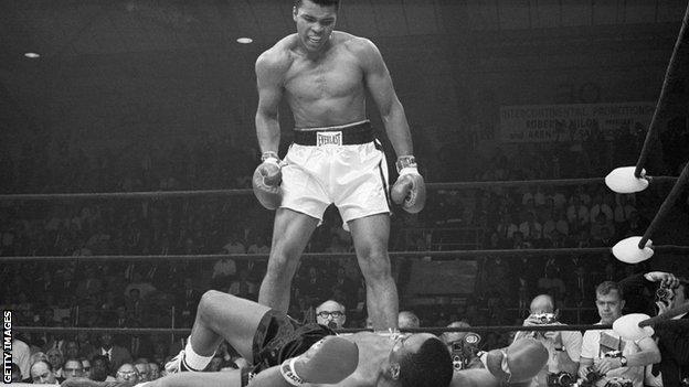 Muhammad Ali stands over Sonny Liston in a black and white photo