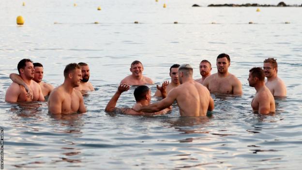 Wales players recover in the sea in Nice after a brutal, battling win against Fiji
