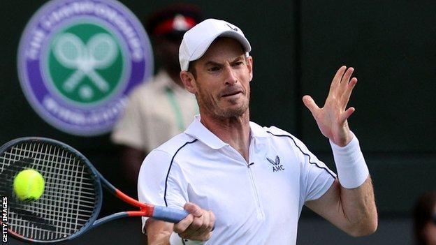 Andy Murray returns a ball in his opening match at Wimbledon 2022