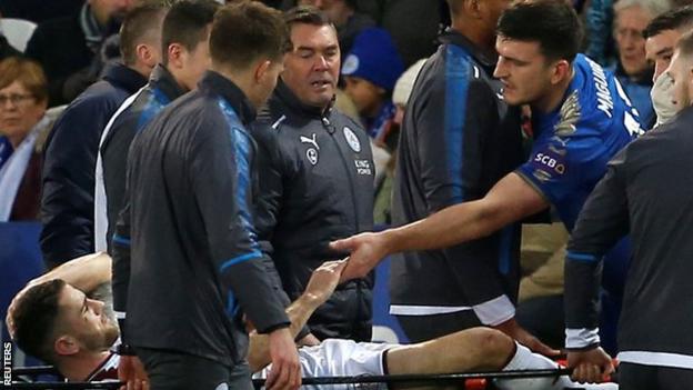 Burnley's Robbie Brady leaves the pitch on a stretcher while Leicester's Harry Maguire passes on his commiserations