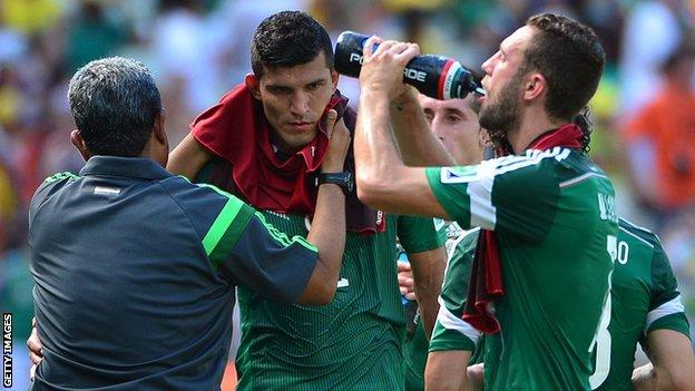 Mexico players have a drinks break during the 2014 World Cup