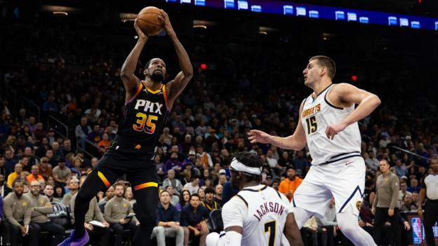 Phoenix Suns forward Kevin Durant (35) drives to the basket against Denver Nuggets centre Nikola Jokic (15) and guard Reggie Jackson (7)