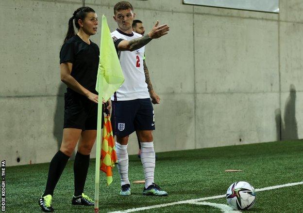 Kieran Trippier of England talks to assistant referee Maryna Striletska during the match between Andorra and England in October 2021