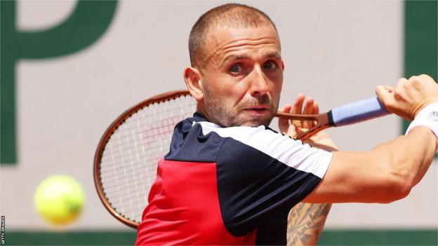 Dan Evans returns a ball against Thanasi Kokkinakis at the French Open