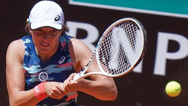 Iga Swiatek returns a ball against Victoria Azarenka at the Italian Open in Rome