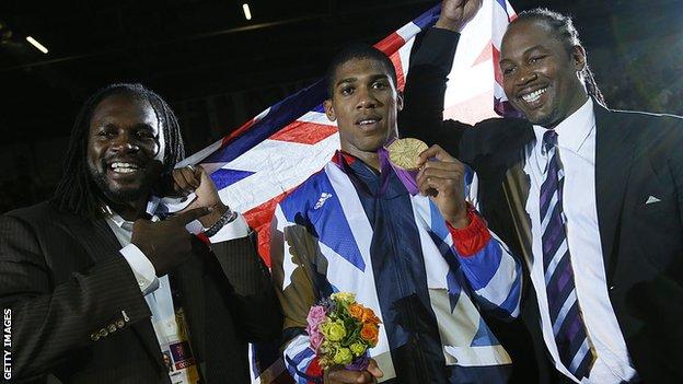 Anthony Joshua is pictured between Audley Harrison and Lennox Lewis at the 2012 Olympics