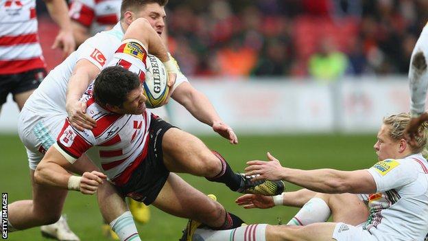 James Hook get through two tackles on the way to scoring Gloucester's opening try