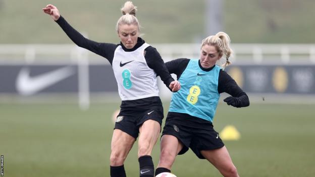 Laura Coombs y Leah Williamson se disputan un balón en un entrenamiento de Inglaterra]