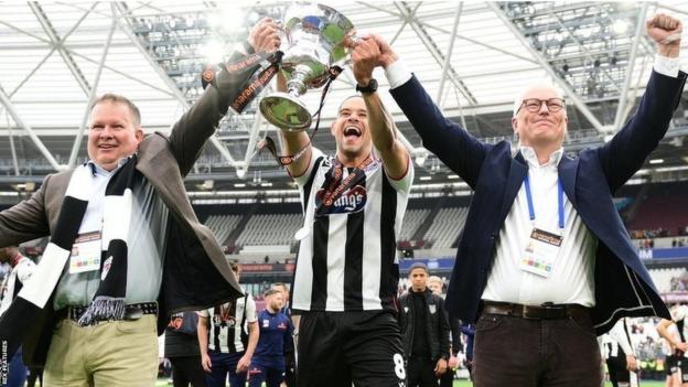 Co-owners Jason Stockwood (right) and Andrew Pettit (left) celebrate with former midfielder Giles Coke after Grimsby Town win promotion to League Tw3