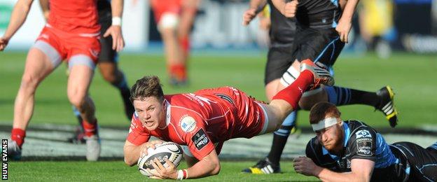 The Scarlets' Steffan Evans is felled by Glasgow's Rob Harley