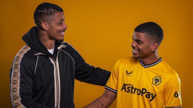 Mario Lemina shakes hands with his brother Noha in a Wolves shirt