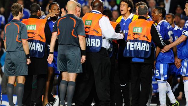 Chelsea striker Didier Drogba points his finger at referee Tom Ovrebo as his team-mates surround officials at the end of their Champions League semi-final exit against Barcelona in 2009
