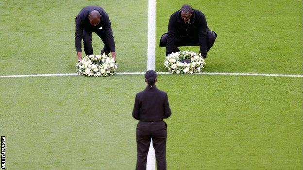 Die ehemaligen Spieler Ledley King und Emile Heskey legen vor Tottenham gegen Leicester Blumen in die Mitte des Spielfelds