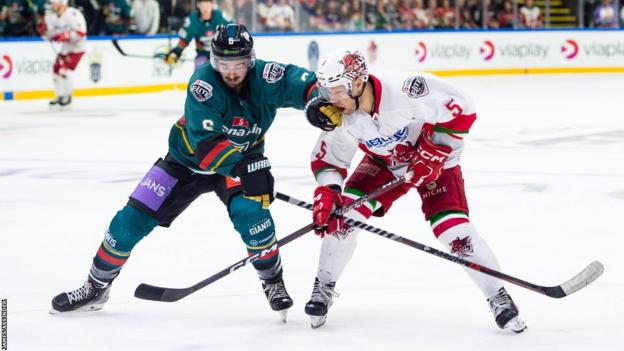 Jeff Baum and Ben Davies compete for the puck