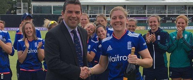 Heather Knight is presented with a bottle of champagne for her heroic efforts in the first ODI against Pakistan
