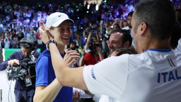 Jannik Sinner celebrates with the Italian team after beating Novak Djokovic at the Davis Cup