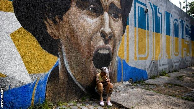 Die Boca Juniors-Frauenspielerin Yamila Rodriguez weint vor dem Graffiti-Bild von Diego Maradona