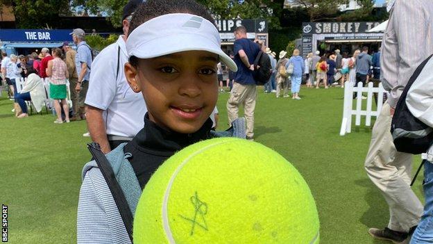 Eden John, 8, poses with a tennis ball signed by Serena Williams