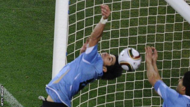 Luis Suarez appears to handle the ball on the line to deny Ghana a late goal at the 2010 World Cup