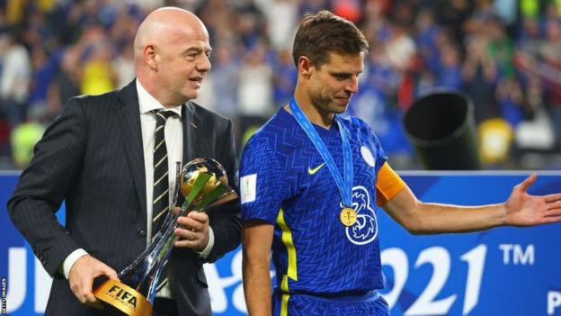 Gianni Infantino prepares to present the Club World Cup trophy to Chelsea captain Cesar Azpilicueta