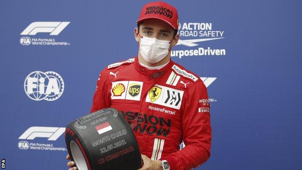 Charles Leclerc holds his pole position award