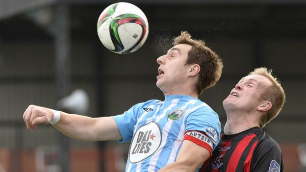 John Boyle of Warrenpoint Town comes under pressure from Crusaders striker Jordan Owens