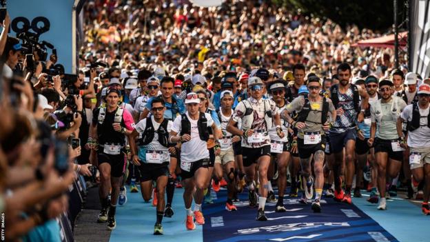 Runners sprint from the start line at UTMB