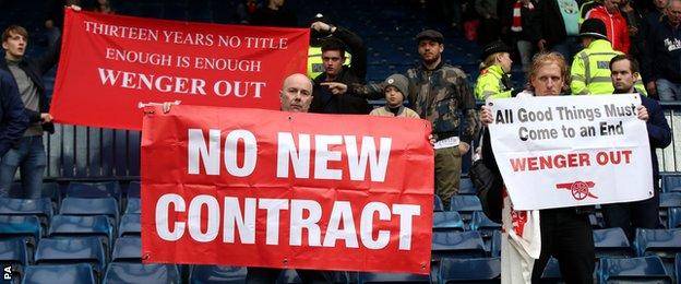 Fans hold banners calling for Arsene Wenger to leave Arsenal