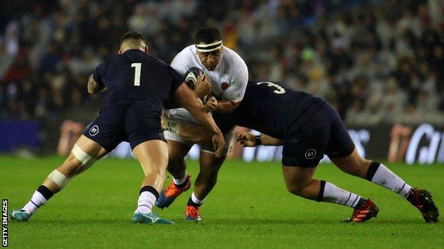 Mako Vunipola is tackled by two Scottish players