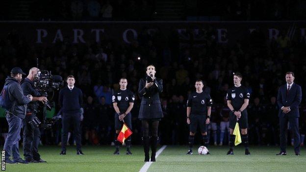 Singer Laura Wright performs the National Anthem at Villa Park following the death of Queen Elizabeth II