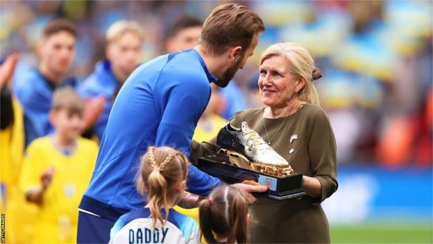 Harry Kane of England is presented with a Golden Boot trophy by FA Chair, Debbie Hewitt