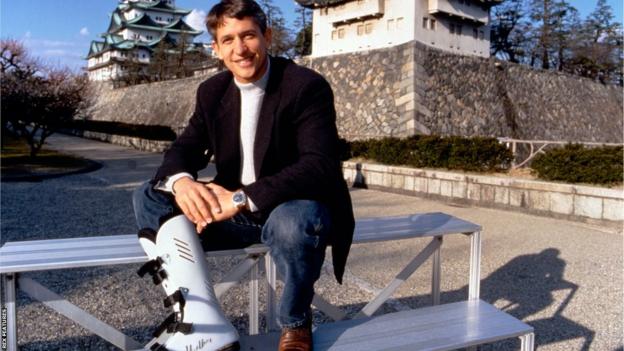Gary Lineker wears a protective boot while he sits in front of temples in Nagoya, Japan
