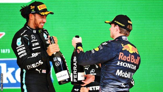 Lewis Hamilton and Max Verstappen hold champagne on the podium