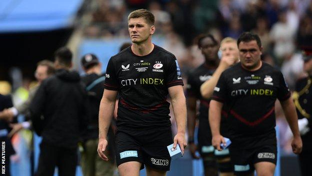 Owen Farrell leads a dejected Saracens team after the Premiership final defeat to Leicester