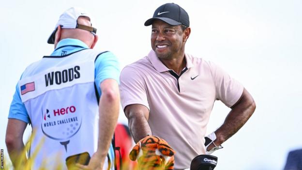 Tiger Woods smiles with his caddie