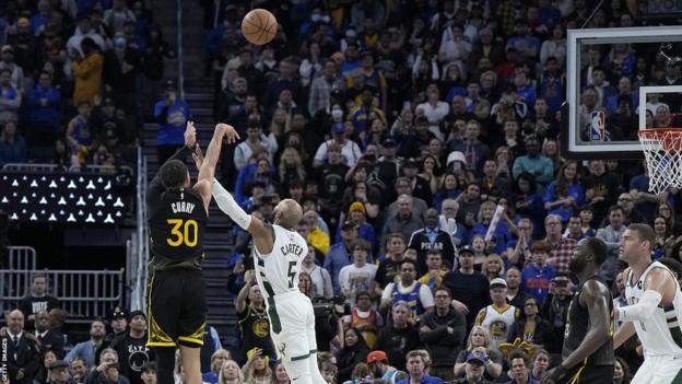 The Golden State Warriors' Stephen Curry makes a three-pointer to tie the game against the Milwaukee Bucks