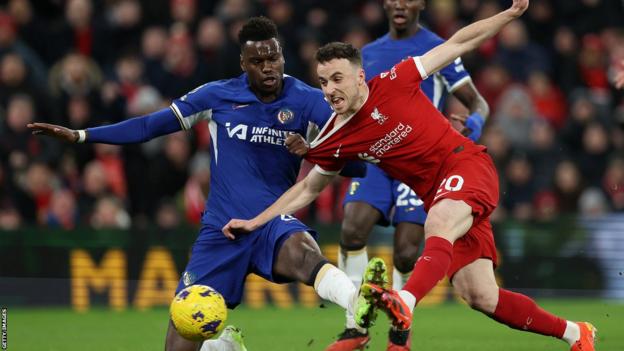 Liverpool's Diogo Jota scores against Chelsea in the Premier League despite being challenged by defender Benoit Badiashile
