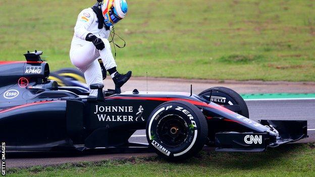 Fernando Alonso steps out of his car after retiring in the Brazilian Grand Prix