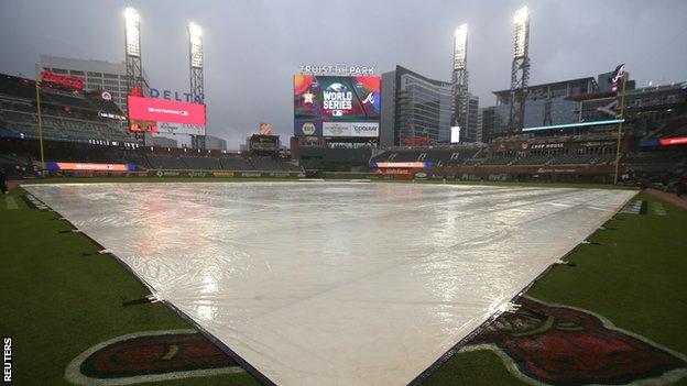 A tarpaulin covers the field at Truist Park