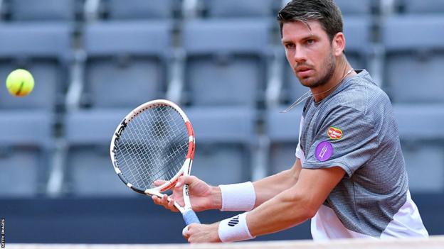 Cameron Norrie hits a shot at the net