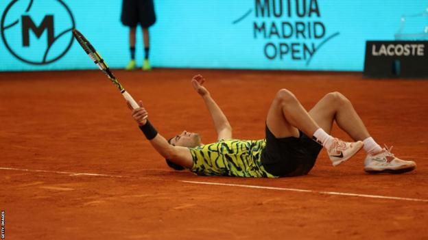 Carlos Alcaraz lies on the court after winning the Madrid Open title