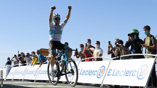 Astana's Alexey Lutsenko raises his arms in celebration after winning stage six of the 2021 Tour de France