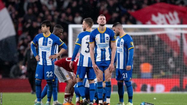 Brighton players look dejected after Solly March's penalty miss