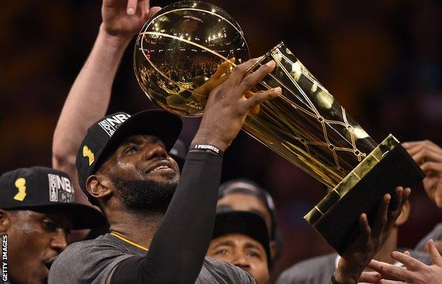 LeBron James holding aloft the NBA Championship trophy in 2016