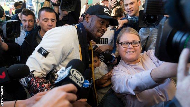 Bolt poses for photographs with the fans at Sydney airport before his stint with Central Coast Mariners