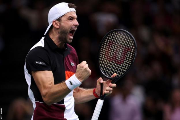 Grigor Dimitrov shouts in delight and punches his fist in the air in celebration towards his box